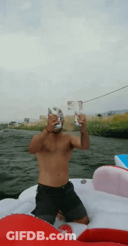 Shirtless Man Sitting On Boat Holding Two Cans GIF