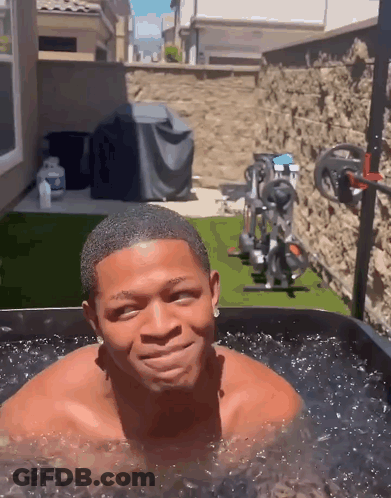 Shirtless Man Smiling In Water Tub GIF
