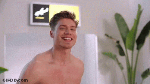 Shirtless Man Smiling Next To Runway Sign GIF