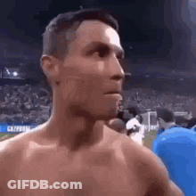 Shirtless Man Standing Before Crowd GIF