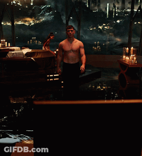Shirtless Man Standing By Candlelit Window GIF