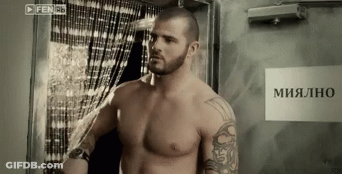 Shirtless Man Standing By Mialno Sign GIF