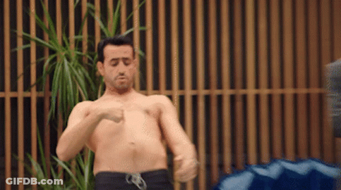 Shirtless Man Standing By Wooden Fence GIF