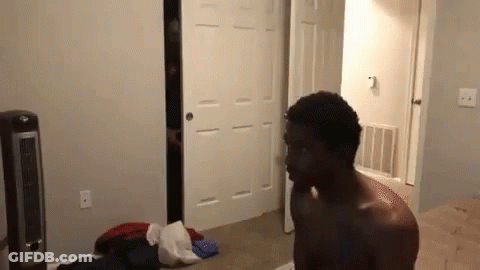Shirtless Man Standing In Bedroom Next To Fan And Closet GIF