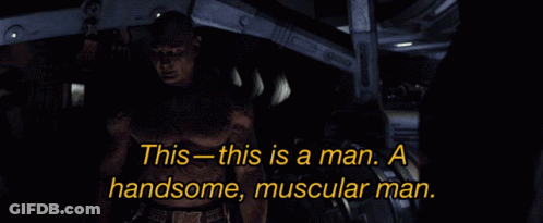 Shirtless Man Standing In Dark Room Saying This Is A Man GIF
