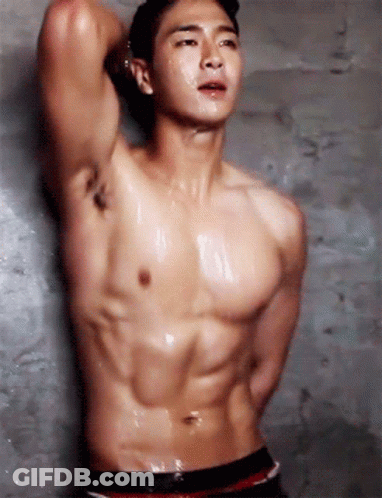 Shirtless Man Standing In Front Of Concrete Wall GIF