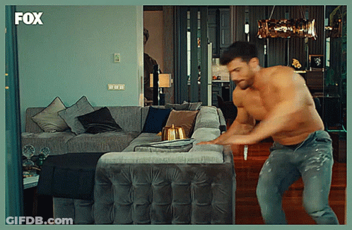 Shirtless Man Standing In Front Of Couch With Fox Logo GIF