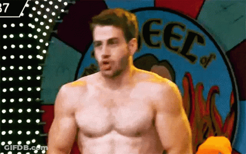 Shirtless Man Standing In Front Of Wheel GIF
