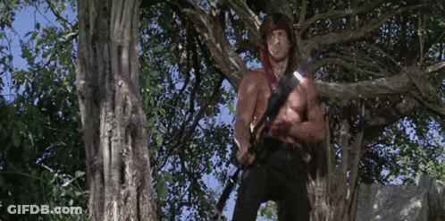 Shirtless Man Standing In Tree With Sword GIF