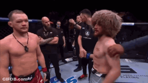 Shirtless Man Standing Next To Man In Boxing Ring GIF