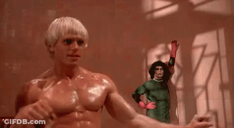 Shirtless Man Standing Next To Woman In Green Costume GIF
