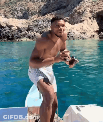 Shirtless Man Standing On Boat GIF