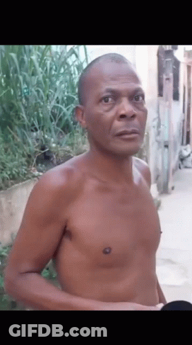 Shirtless Man Standing On Sidewalk GIF