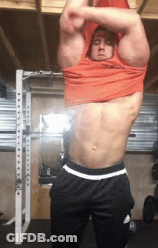 Shirtless Man Taking Off Shirt In Garage GIF