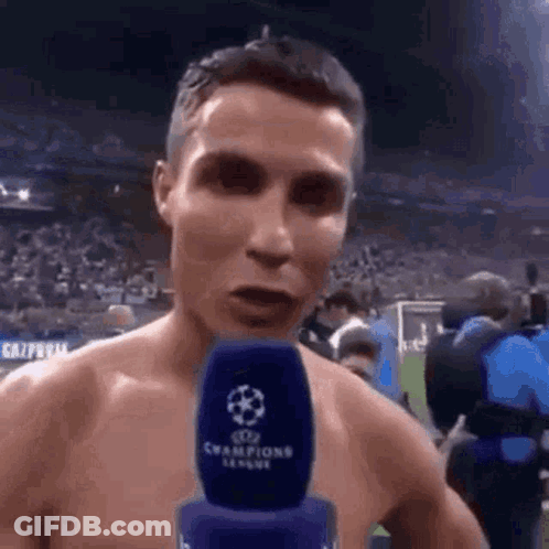 Shirtless Man Talking Into Microphone On Field GIF