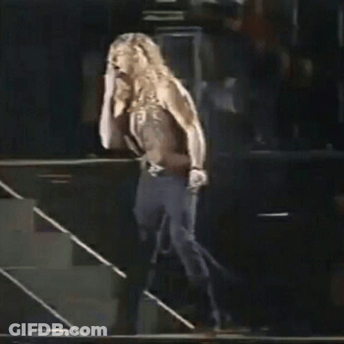 Shirtless Man Walking Down Stairs On Stage Holding Microphone GIF