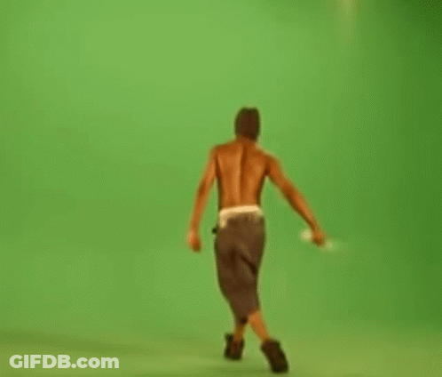 Shirtless Man Walking On Green Screen Holding Stick GIF