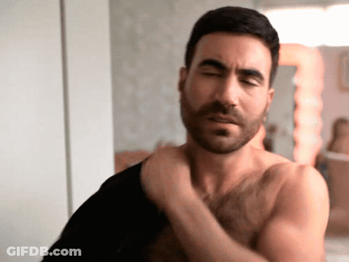 Shirtless Man With Beard Adjusting Shirt GIF
