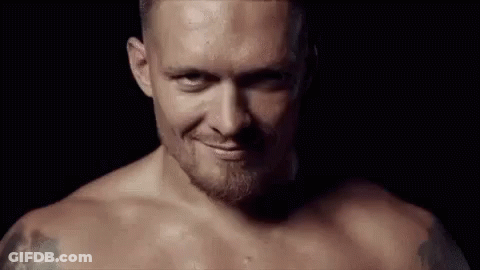 Shirtless Man With Beard Smiling In Dark Room GIF