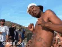 Shirtless Man With Chest Tattoo Dancing Before Crowd GIF