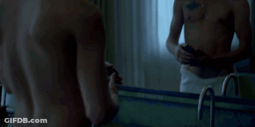 Shirtless Man With Chest Tattoo Looking At Phone GIF