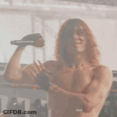Shirtless Man With Curly Hair Holding Microphone Flexing GIF