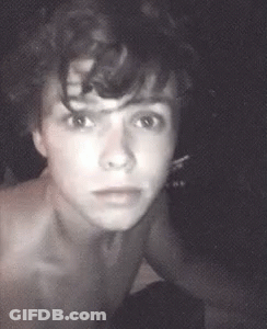 Shirtless Man With Curly Hair Looking At Camera GIF