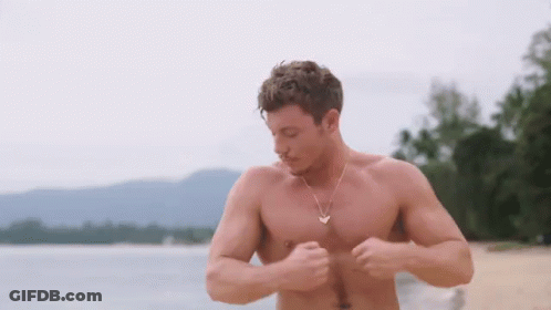 Shirtless Man With Gold Necklace On Beach GIF
