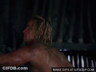 Shirtless Man With Hands On Hips By Fence GIF