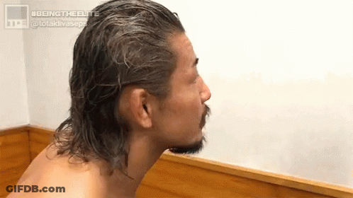 Shirtless Man With Long Hair And Beard Sitting On Wooden Bench GIF