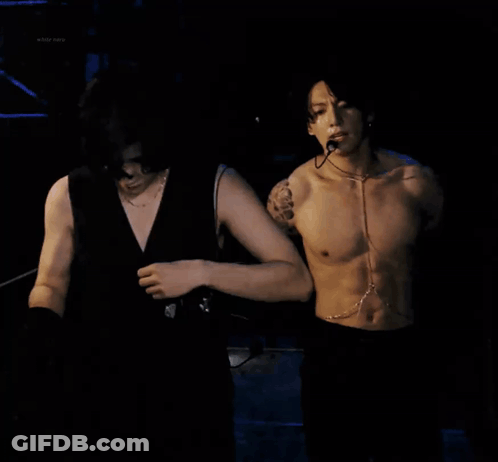 Shirtless Man With Microphone Next To Another Man GIF