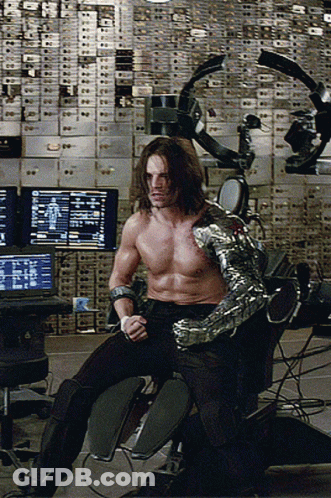 Shirtless Man With Robotic Arm Sitting At Computer GIF