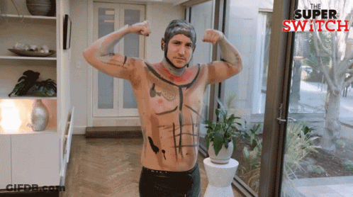 Shirtless Man With Tattoo Smiling Beside Another GIF