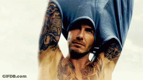 Shirtless Man With Tattoos Holding Shirt Over Head GIF