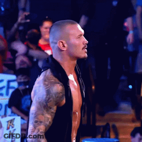 Shirtless Man With Tattoos Standing In Front Of Crowd GIF