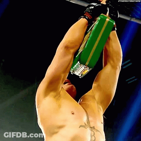 Shirtless Wrestler Hanging Upside Down Holding Green Belt Saying The Next Big Thing GIF