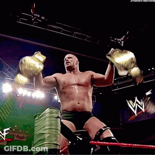 Shirtless Wrestler Holding Two Championship Belts GIF