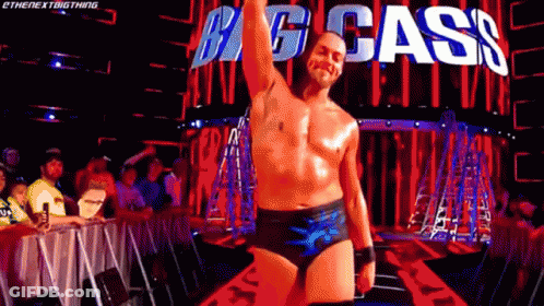 Shirtless Wrestler In Front Of Big Cass Sign GIF