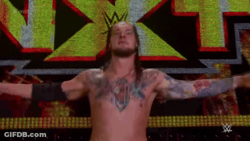 Shirtless Wrestler In Front Of Large X On Screen GIF