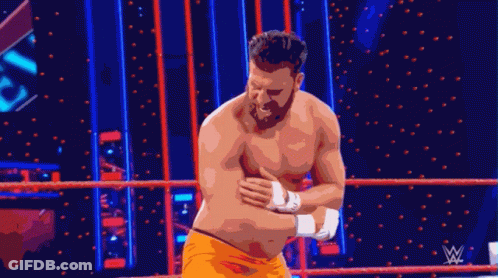 Shirtless Wrestler Standing In Ring With Wrestling Logo GIF
