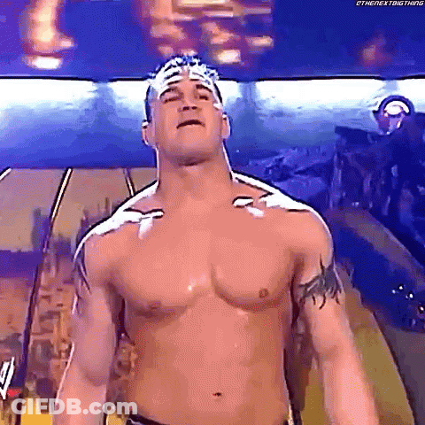 Shirtless Wrestler With Bandage On Head Standing In Room GIF