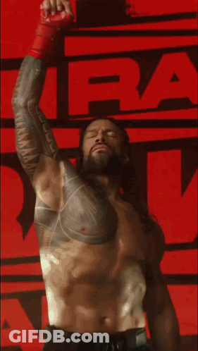 Shirtless Wrestler With Chest Tattoo Raising Arm GIF