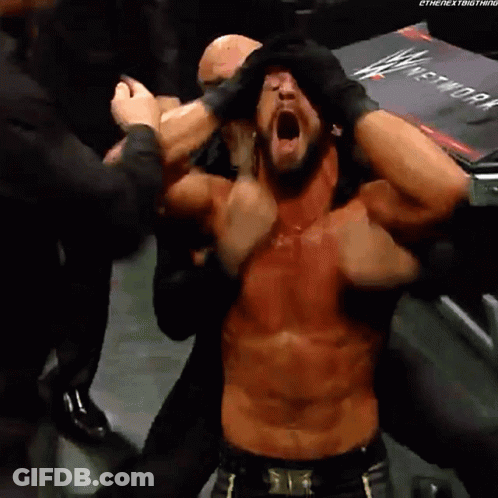 Shirtless Wrestler With Mouth Open Surrounded By People GIF