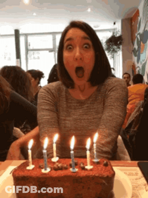 Shocked Woman Blowing Birthday Candles GIF