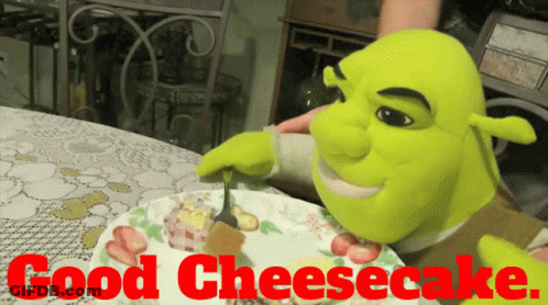 Shrek Is Eating A Cheesecake On A Plate With The Words Good Cheesecake Behind Him GIF