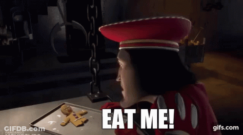 Shrek Is Eating A Gingerbread Man On A Tray And Says Eat Me ! GIF