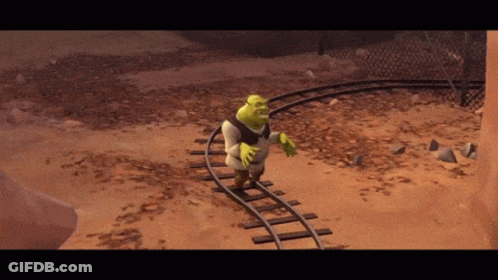 Shrek Is Walking On Train Tracks In A Desert GIF