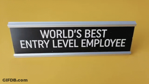 Sign On Yellow Wall Says World's Best Entry Level Employee GIF