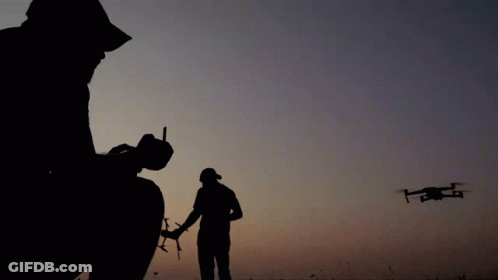 Silhouette Man Holding Remote Control With Drone GIF