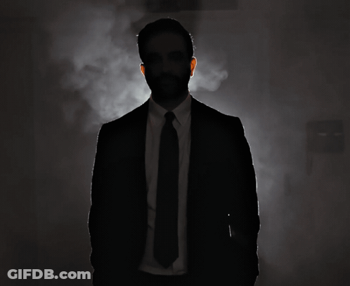 Silhouette Of Man In Suit And Tie In Dark Room GIF
